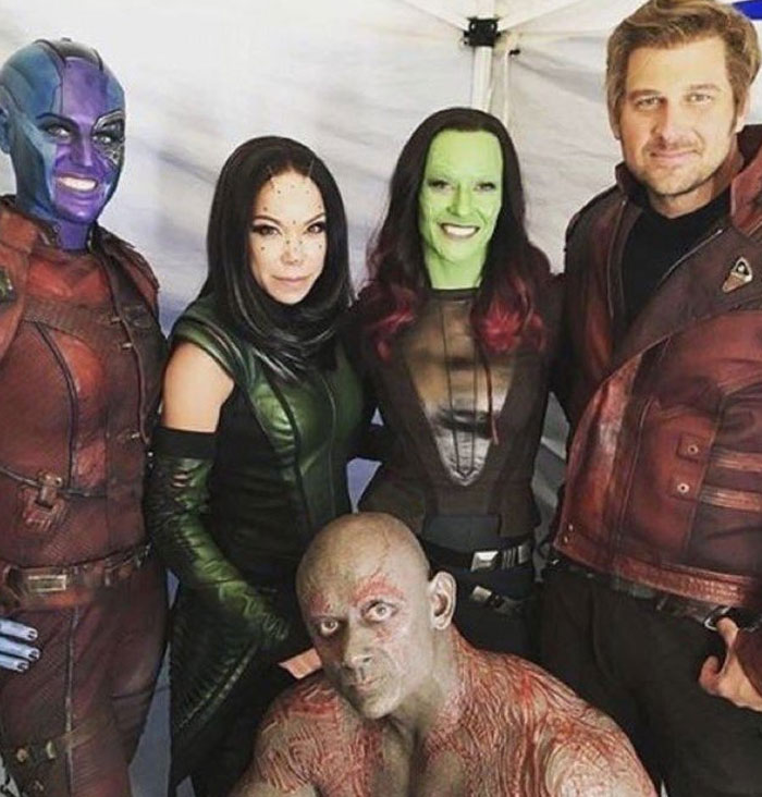 Behind-the-scenes photo of movie cast in full costume and makeup, capturing unhinged and memorable moments for memes.
