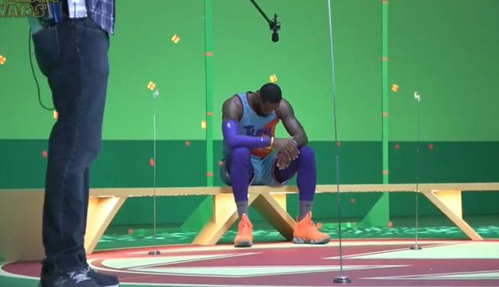 Athlete in colorful sportswear sitting on bench on a film set with green screen, captured in unhinged behind-the-scenes moment.