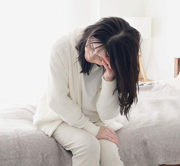 Woman sitting on bed looking distressed, reflecting emotions related to best friend no contact returns situation. Woman sitting on bed looking distressed, reflecting emotions related to best friend no contact returns situation.