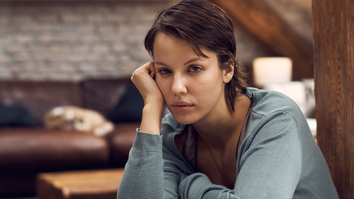Young woman looking thoughtful and pensive indoors, representing feelings about best friend no contact returns.