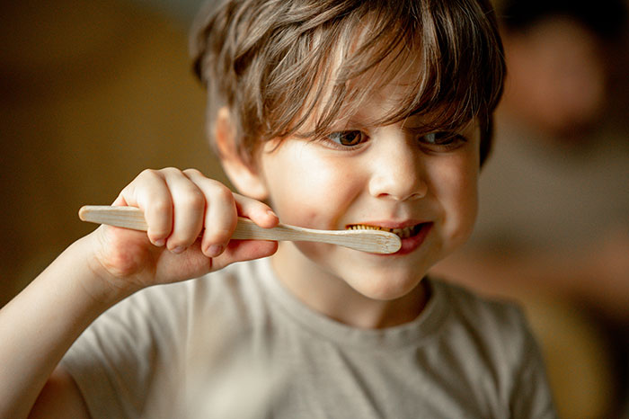 Young boy brushing his teeth indoors, highlighting a family setting during a power trip and Halloween conflict with stepmom. Young boy brushing his teeth indoors, highlighting a family setting during a power trip and Halloween conflict with stepmom.