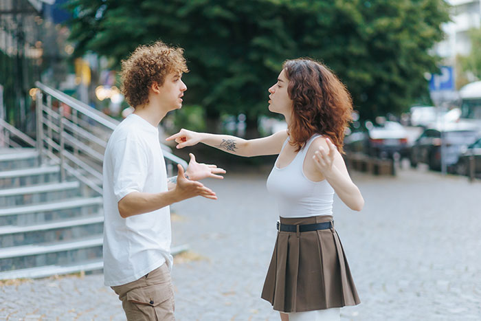 Man and woman arguing outdoors, tense confrontation showing conflict after discovering she secretly went clubbing. Man and woman arguing outdoors, tense confrontation showing conflict after discovering she secretly went clubbing.