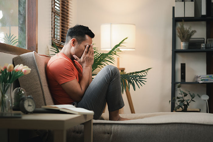 Man upset and stressed on sofa after discovering girlfriend secretly went clubbing and lost his car at home. Man upset and stressed on sofa after discovering girlfriend secretly went clubbing and lost his car at home.