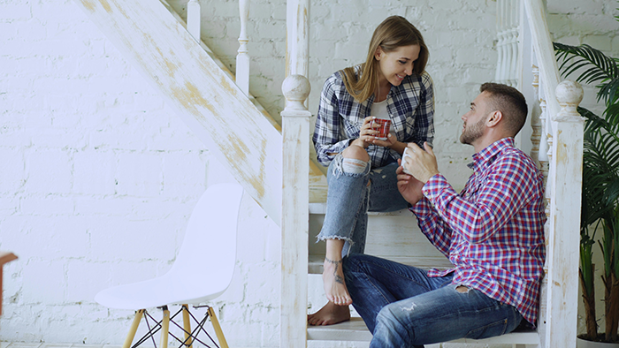 Couple having a serious conversation on stairs about financing a renovation and marriage appearing like a transaction. Couple having a serious conversation on stairs about financing a renovation and marriage appearing like a transaction.