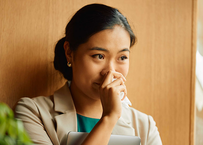 Young woman reflecting thoughtfully by a wooden wall, symbolizing a new life and success in France after leaving the US. Young woman reflecting thoughtfully by a wooden wall, symbolizing a new life and success in France after leaving the US.