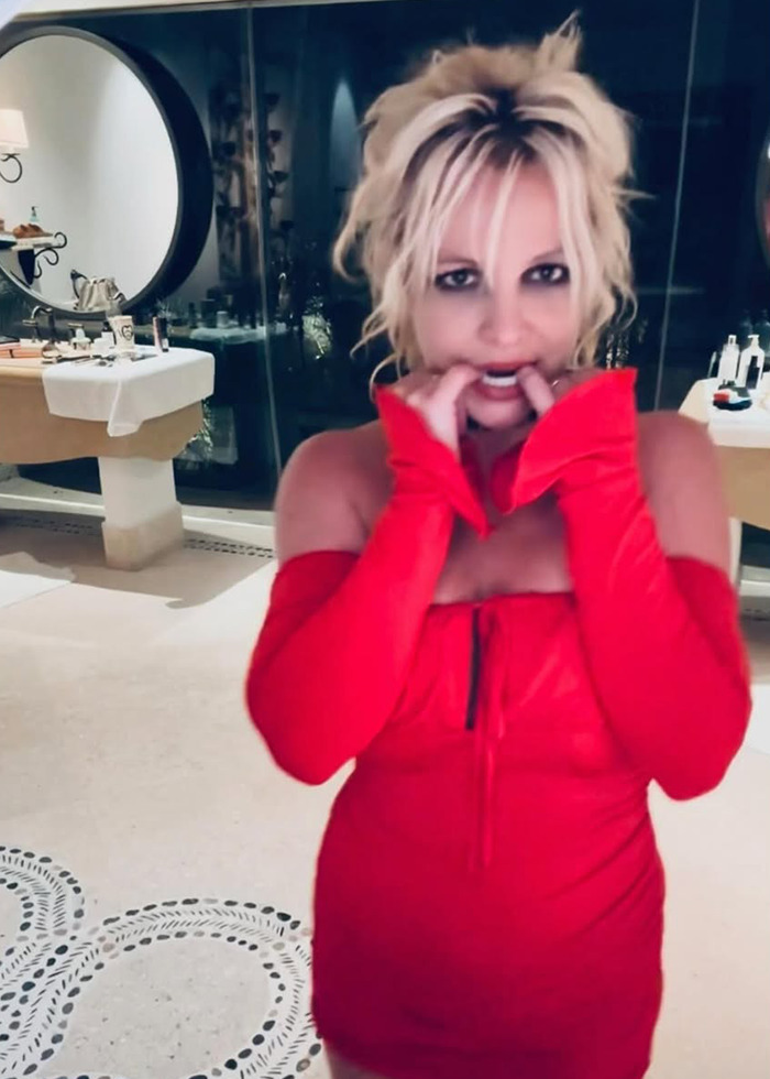Britney Spears in a red dress in a bathroom, her cryptic post about sadness and darkness raising well-being concerns. Britney Spears in a red dress in a bathroom, her cryptic post about sadness and darkness raising well-being concerns.