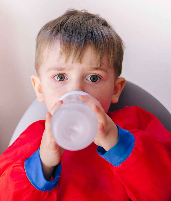 Young child drinking from a bottle, illustrating the theme of businesses that lost clients with bad decisions.