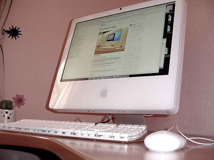 Apple desktop computer on a wooden desk displaying a webpage, illustrating businesses losing clients with poor decisions.