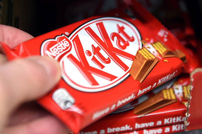 Hand holding a KitKat chocolate bar, illustrating businesses that lost clients with stupid decisions.