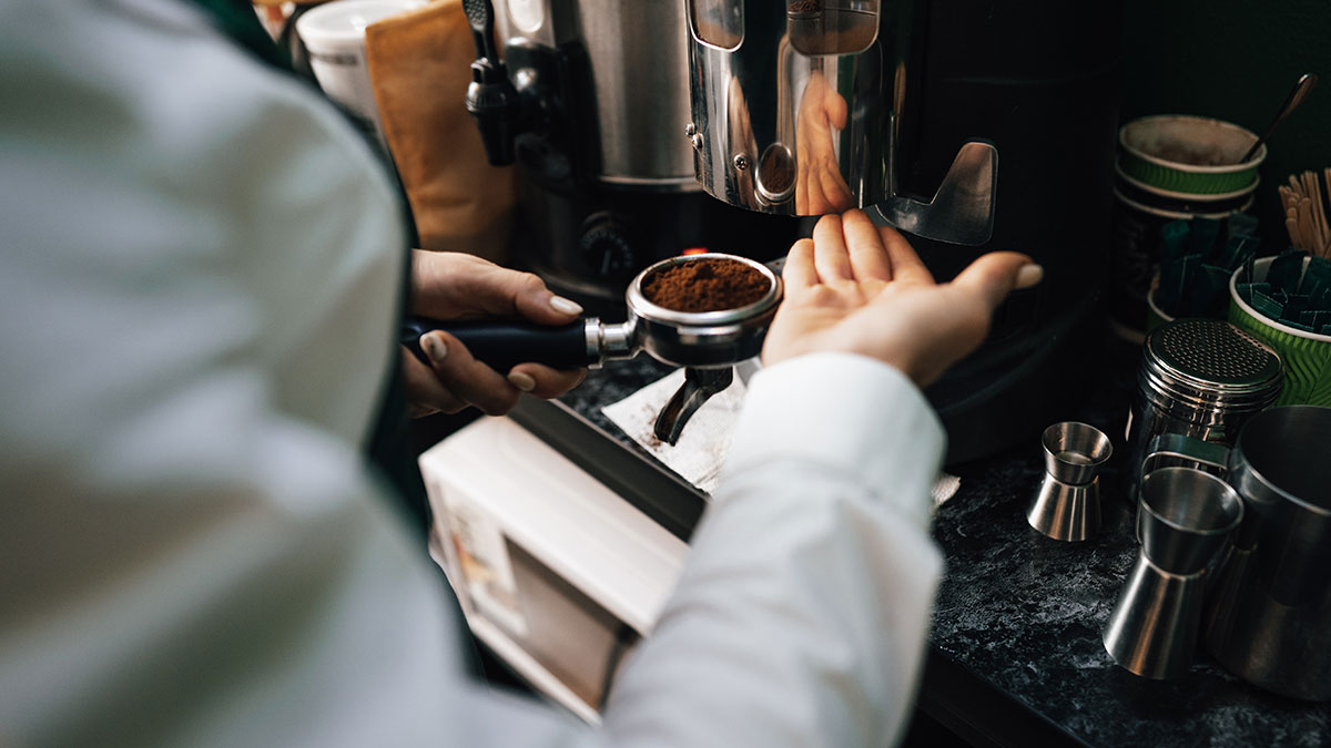 Barista preparing espresso with coffee grounds using a machine, illustrating businesses that lost clients with poor decisions.