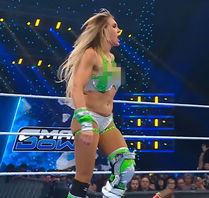 Female wrestler in green and silver outfit performing in a ring with an audience, celebrity revealed moments sparking a frenzy. Female wrestler in green and silver outfit performing in a ring with an audience, celebrity revealed moments sparking a frenzy.