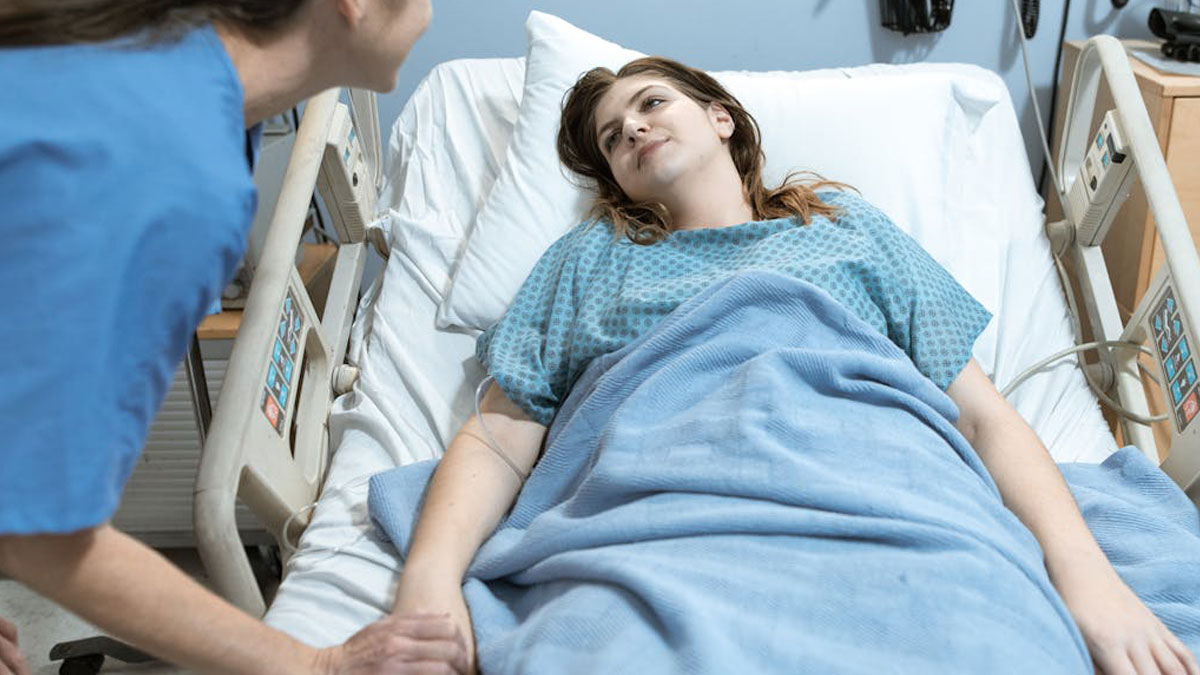 Patient in hospital bed holding nurseu2019s hand, symbolizing experiences of people who came back to life.