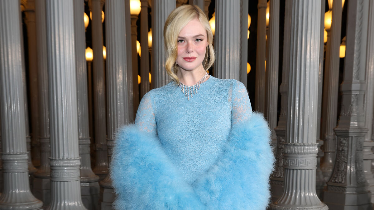 Woman in a blue lace dress and fluffy shawl posing at 2025 LACMA Art and Film Gala fashion event at night.