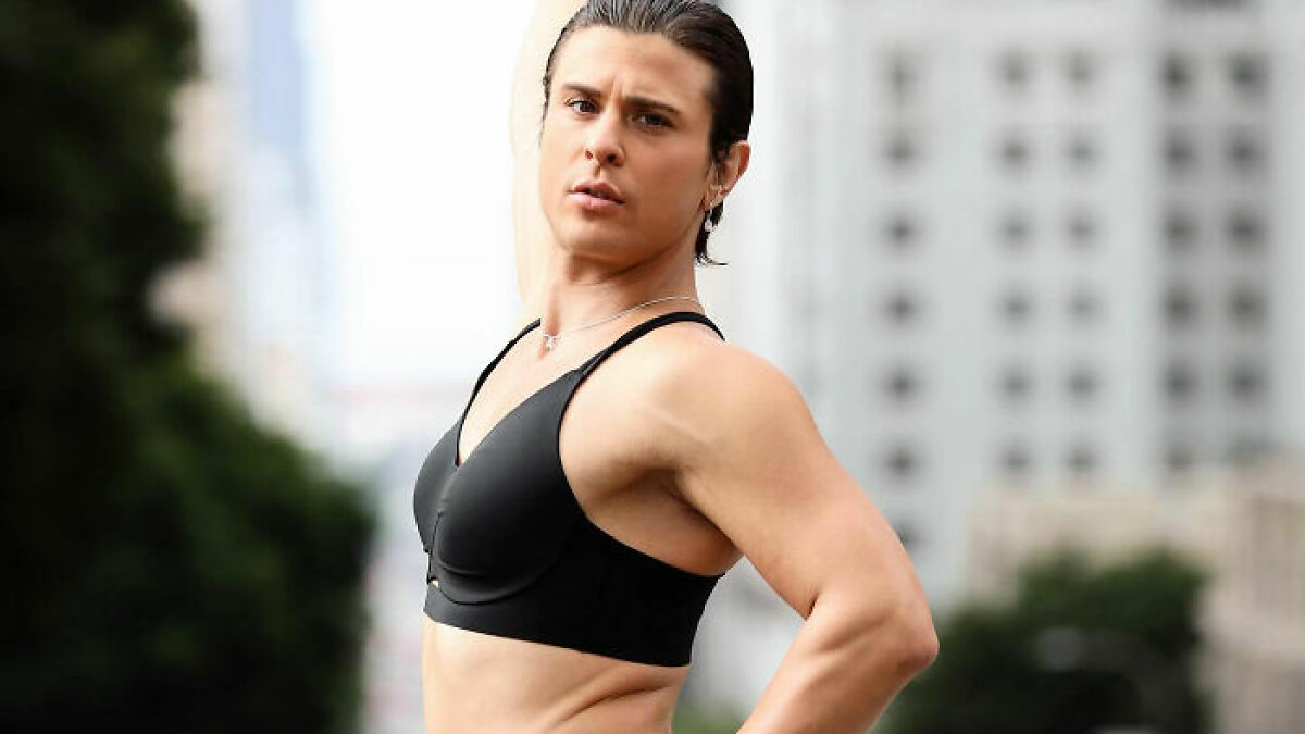 Trans woman posing outdoors in black sports bra, showing strength and confidence after gym locker room confrontation.