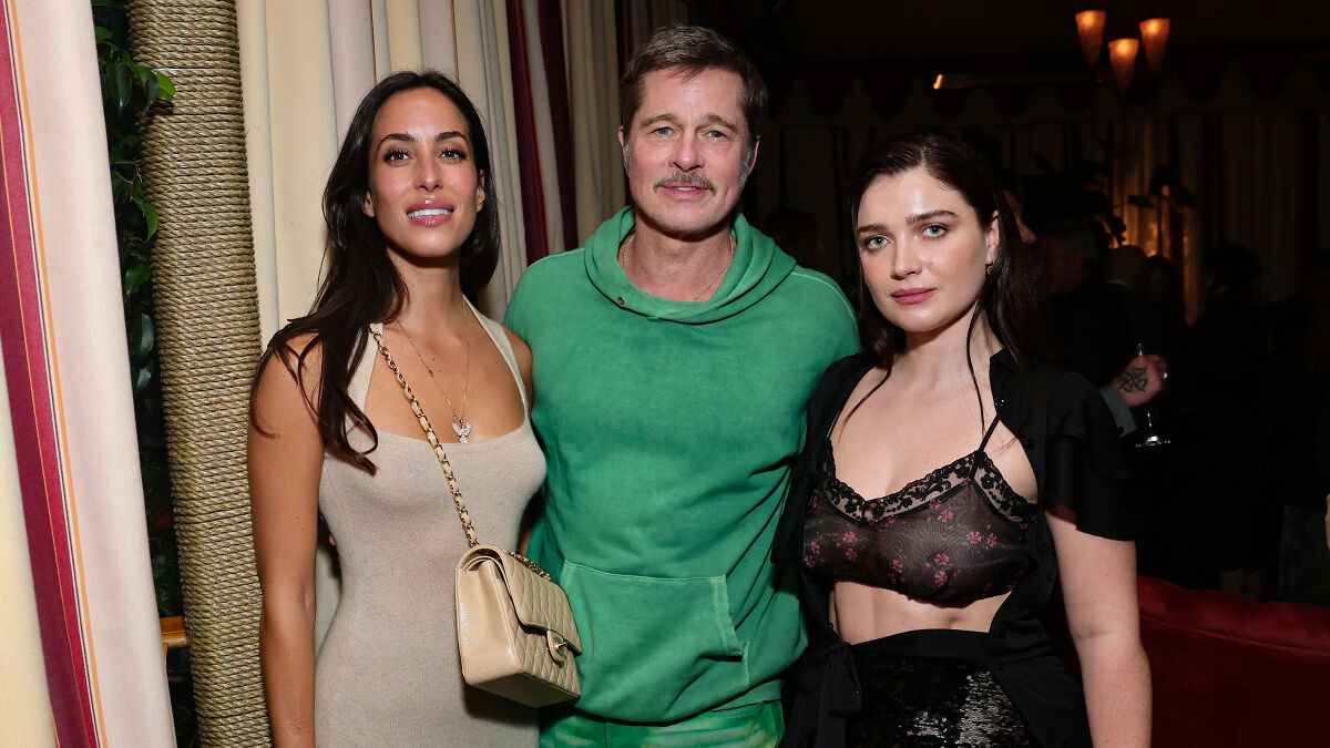 Brad Pitt at Hollywood premiere wearing a green hoodie posing with two women amid speculation of his appearance.