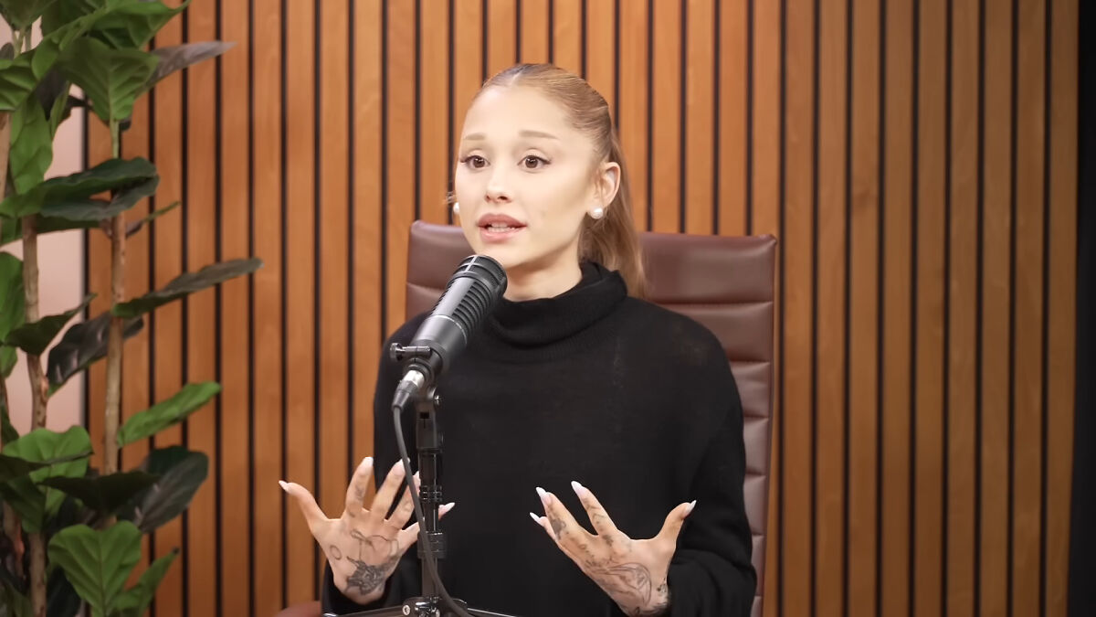 Ariana Grande speaking into a microphone during a podcast, discussing her cryptic last hurrah announcement.