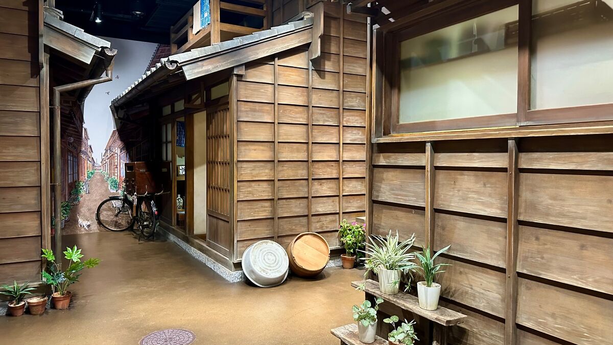 Miniature wooden street scene with plants and bicycle inside Tokyou2019s tiny Time Machine Museum in Ueno, Japan.