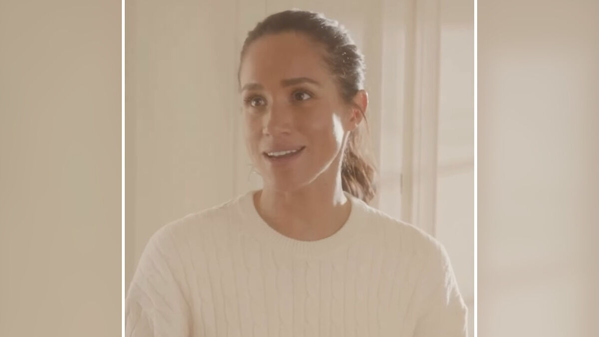 Meghan Markle wearing a white sweater, smiling indoors in a bright room, related to Thanksgiving turkey faux pas discussion
