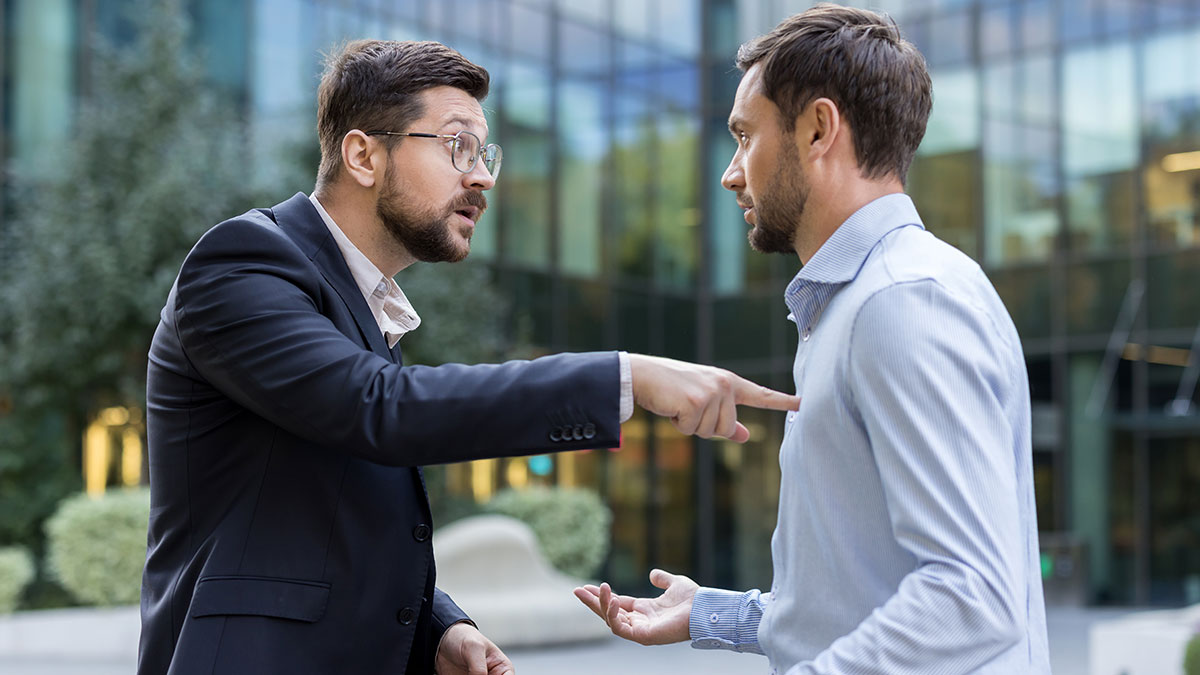 Two men in a heated discussion outside an office building, highlighting a serious conflict over an office chair.