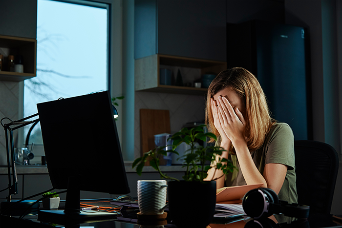 Frustrated coworker in office covering face in tears after employee takes everything during office swap conflict at workstation. Frustrated coworker in office covering face in tears after employee takes everything during office swap conflict at workstation.