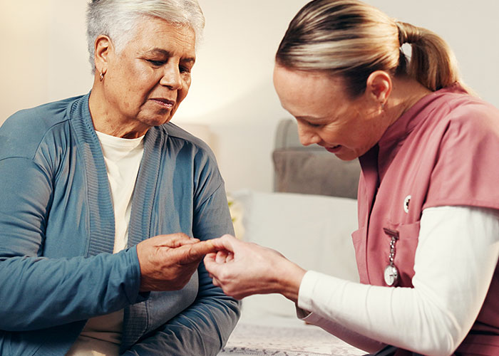 Nurse examining elderly patient’s finger in an ER setting, highlighting weird and crazy ER stories experiences.