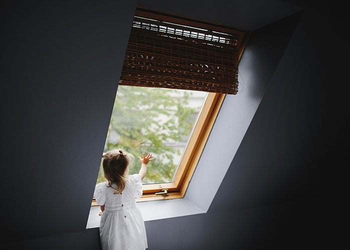 Young girl in white dress reaching toward a window, evoking themes of narrowly avoided kidnapping and disturbing stories.