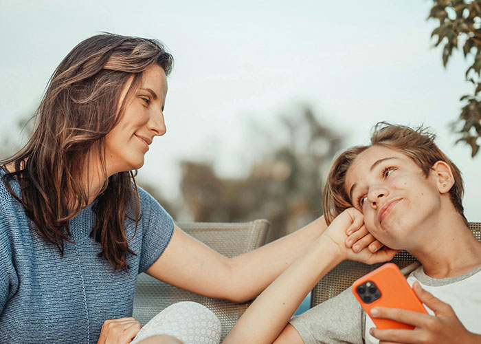 Woman and teenager sharing a tender moment outdoors, illustrating emotions related to narrowly avoided being kidnapped stories.