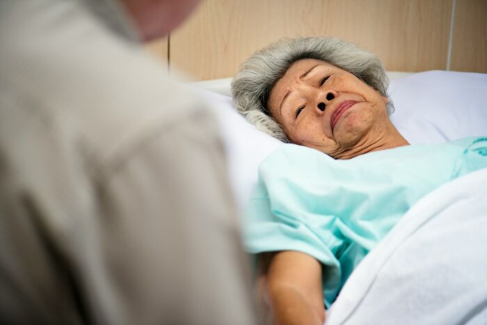 Elderly woman in hospital bed sharing heavy confessions with a visitor she refused to take to her grave.