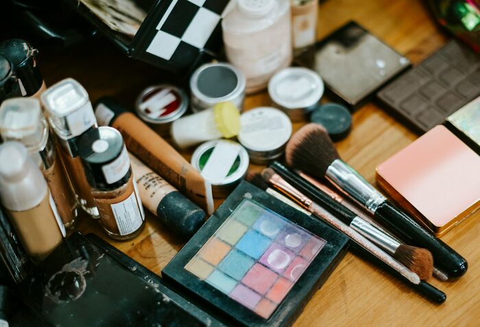 Makeup and beauty products scattered on a wooden surface revealing surprising habits discovered after moving in with a partner