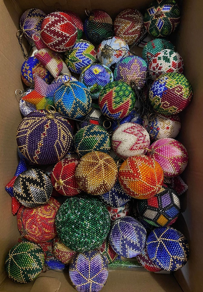 Colorful crochet projects of beaded ornaments with various patterns in a box, showcasing crochet enthusiasts' proud creations.
