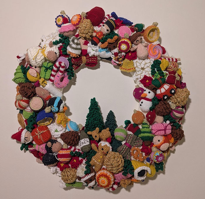 Colorful crochet wreath with holiday-themed designs, showing the pride of crochet enthusiasts in their handmade projects.