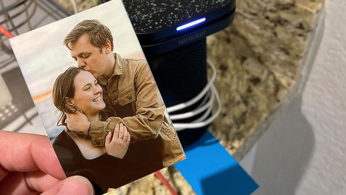 Small photo print being held near a compact photo printer, highlighting Cyber Monday tech deals for the weekend.