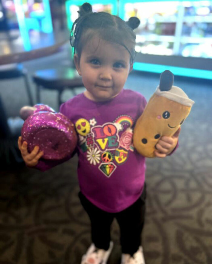 Toddler girl holding toys indoors with focus on young child relating to man leaving 2YO daughter in burning car incident.