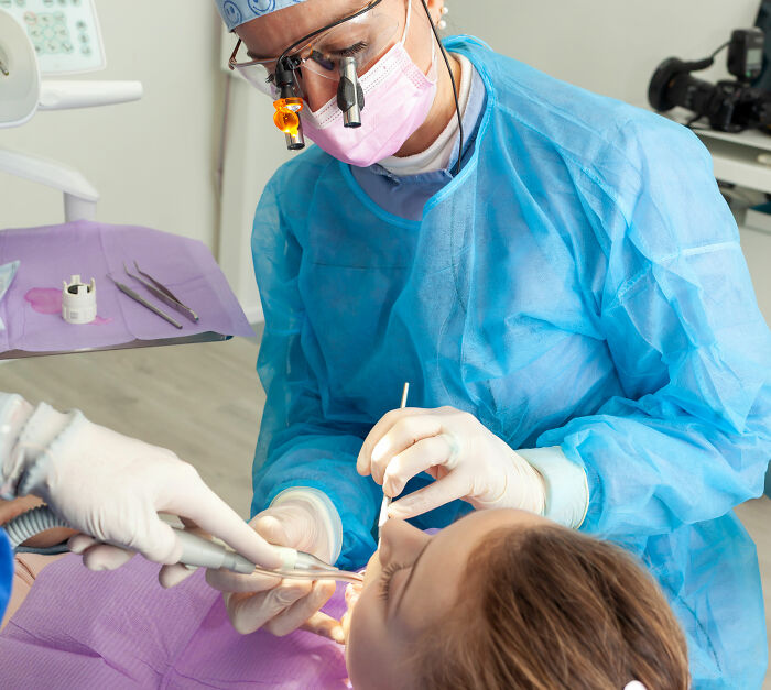 Dentist performing oral procedure on patient, emphasizing water's powerful role in dental safety and treatment.