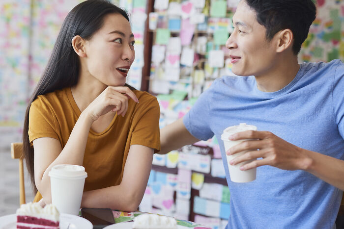 A young couple enjoying drinks and cake together, highlighting the powerful impact of water in daily life.