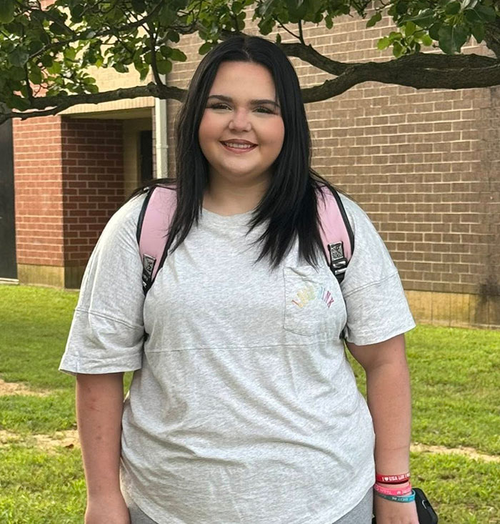 Teen girl with backpack smiling outdoors, facing relentless bullying at school over racist name before changing it. Teen girl with backpack smiling outdoors, facing relentless bullying at school over racist name before changing it.
