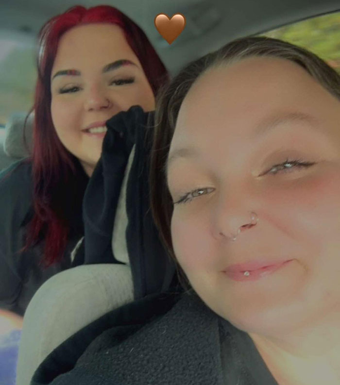 Mother and teenage daughter smiling in a car after daughter changes her racist name due to bullying at school.