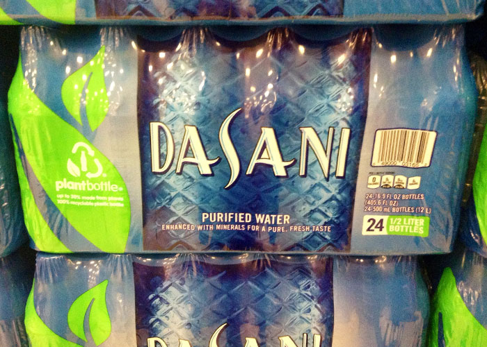 Packaged Dasani purified water bottles with plant bottle recycling logo, representing companies competing for Corporate Darwin Award.
