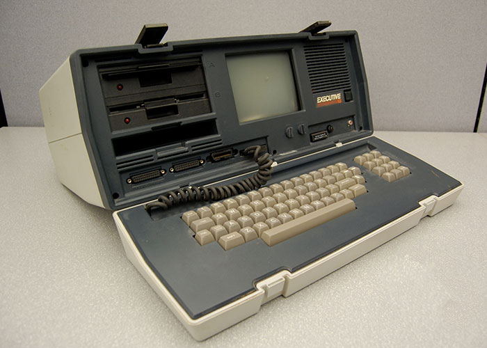Vintage portable computer with built-in screen and keyboard, symbolizing companies competing for corporate Darwin award
