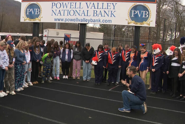 Group of people gathered on a football field in a moment of silence, related to missing football coach case updates. Group of people gathered on a football field in a moment of silence, related to missing football coach case updates.