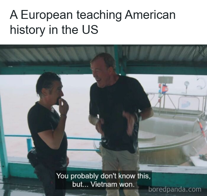 Two men laughing under a shelter with a meme about history, featuring hilarious history memes for museum exhibit content.