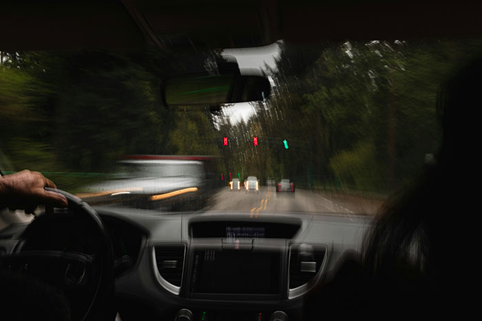 View from inside a car at night with blurred traffic lights, illustrating a viral rear-ending incident involving a police officer. View from inside a car at night with blurred traffic lights, illustrating a viral rear-ending incident involving a police officer.