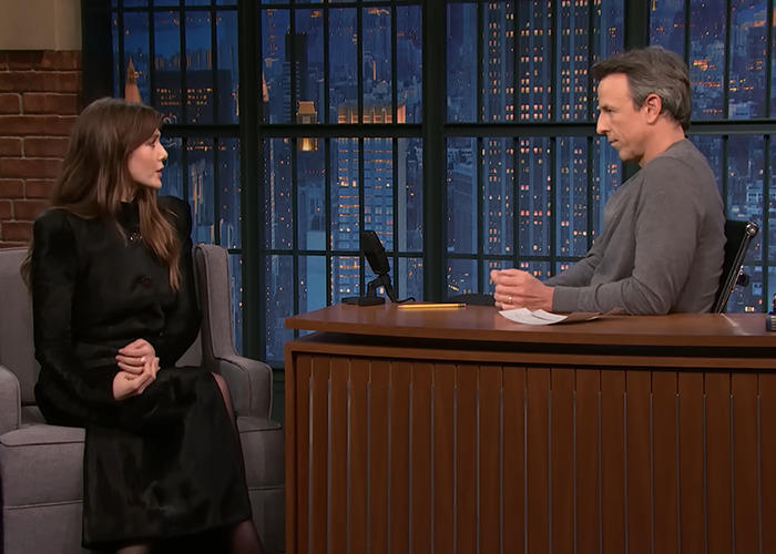 Elizabeth Olsen in a black dress discussing the viral 6,7 meme during a late-night talk show interview. Elizabeth Olsen in a black dress discussing the viral 6,7 meme during a late-night talk show interview.