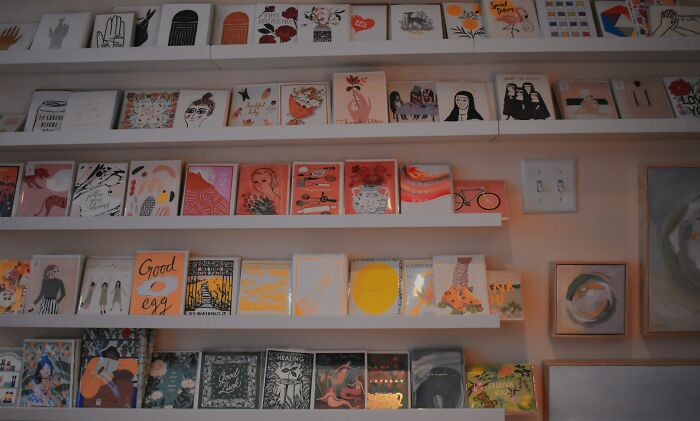 Wall display of colorful art prints and illustrations reflecting surprising habits and secrets discovered after moving in with a partner.
