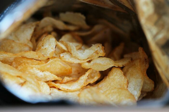 Close-up of crispy potato chips inside an open bag illustrating surprising habits and secrets discovered after moving in with a partner.