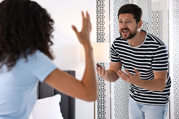 Man in striped shirt angrily arguing with woman raising her hand, depicting a cheating husband confrontation scene. Man in striped shirt angrily arguing with woman raising her hand, depicting a cheating husband confrontation scene.