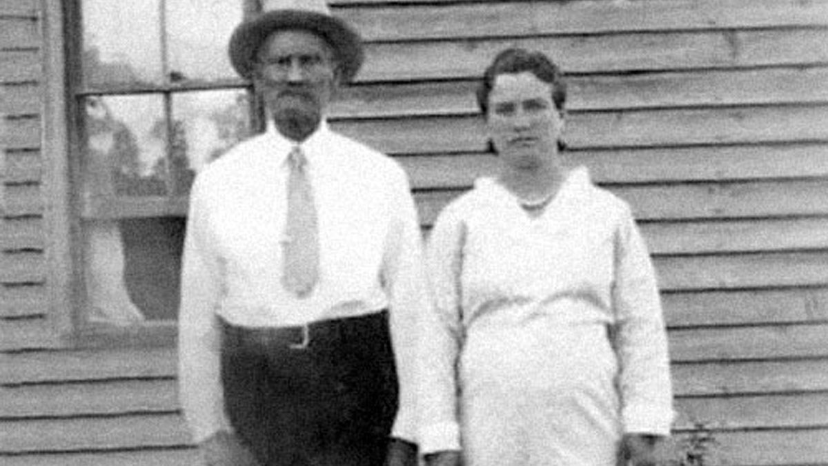 Black and white photo of two people standing outside a wooden building, illustrating favorite true facts that seem unreal.