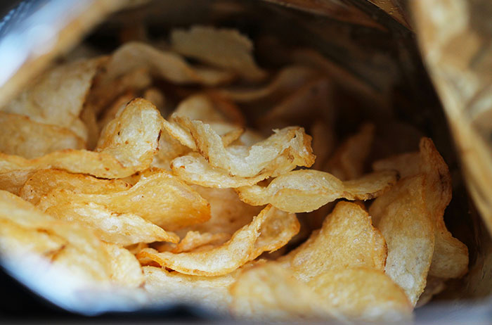 Close-up of crispy potato chips inside a snack bag, illustrating unexpected moments in everyday life stories.