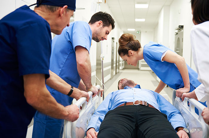 Medical team rushing a patient on a stretcher through a hospital corridor in an unexpected life-threatening emergency situation