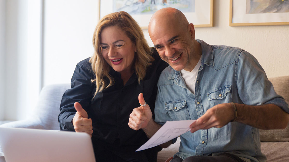 Man and woman smiling and giving thumbs up while looking at laptop, illustrating daughter panic over $15K charge.